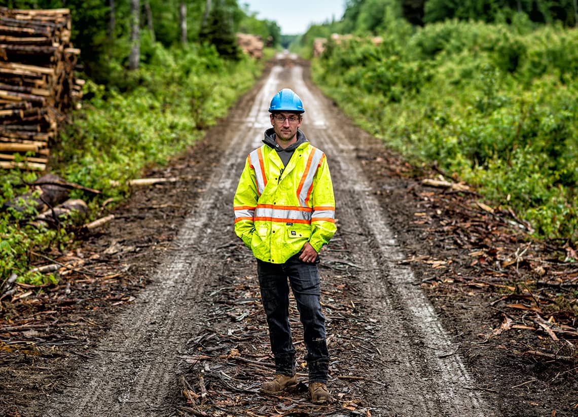 Shot of a logger standing on a forest road