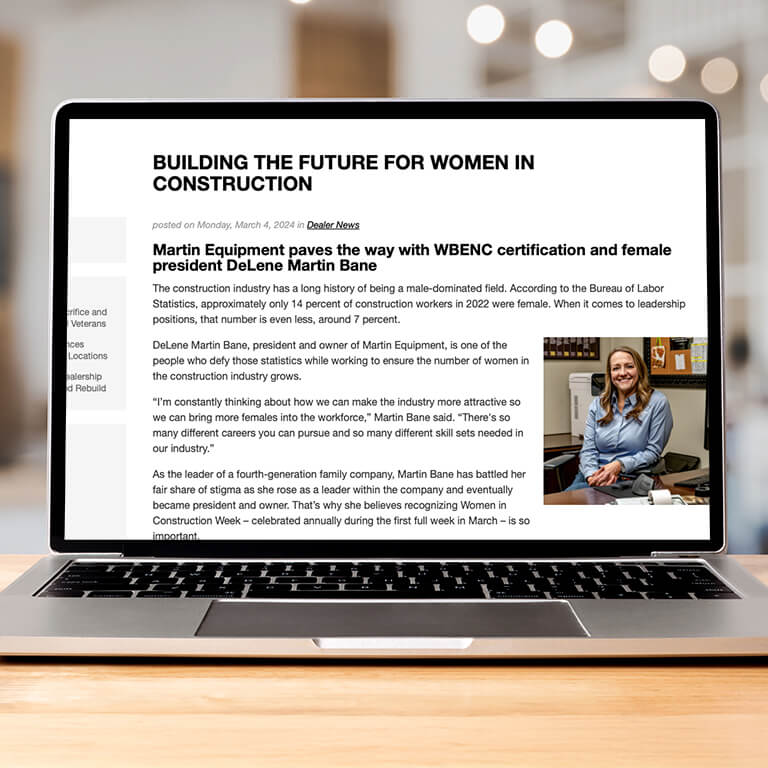 Laptop sitting on a desk with a page from the Martin Equipment website pulled up displaying a story about women ownership